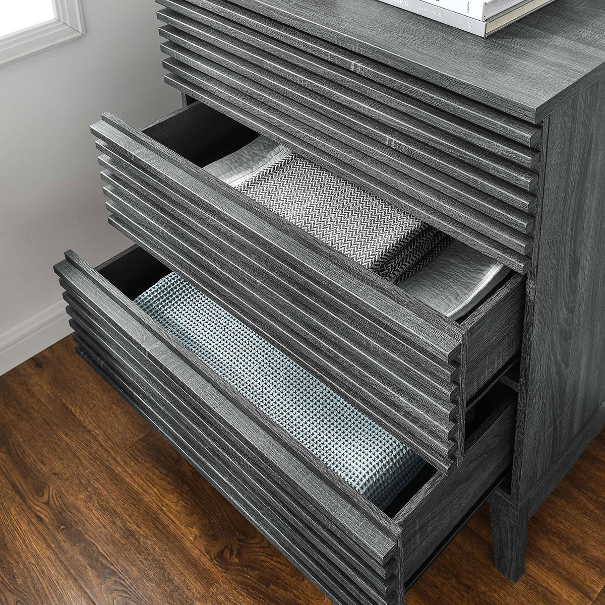 Open drawers neatly organizing folded textiles inside the charcoal bachelor's chest in a bright bedroom || MOD-6965-CHA || storage_open_room
