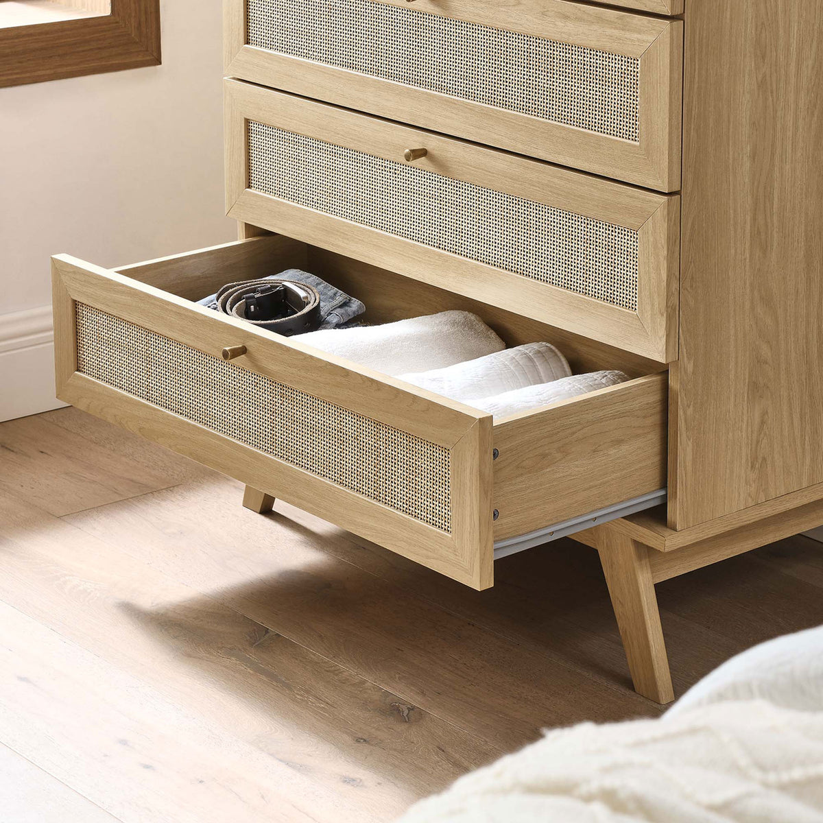 Open lower drawer of chest in bright bedroom showing storage for towels and accessories || MOD-7052-OAK || storage_open_room