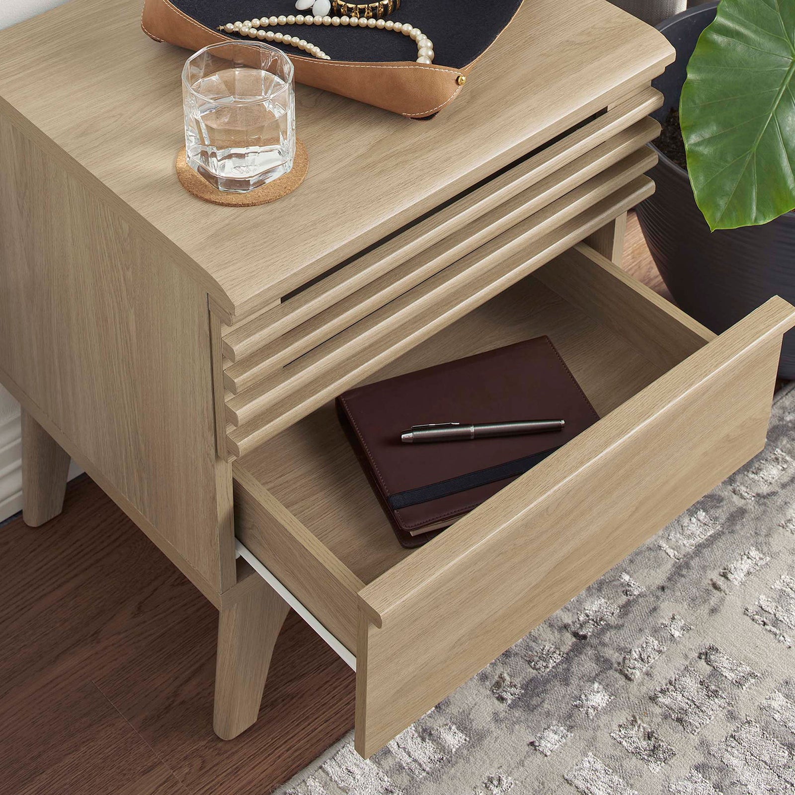 Nightstand drawer pulled open to store bedside essentials on a textured rug and warm wood floor || MOD-7071-OAK || storage_open_room