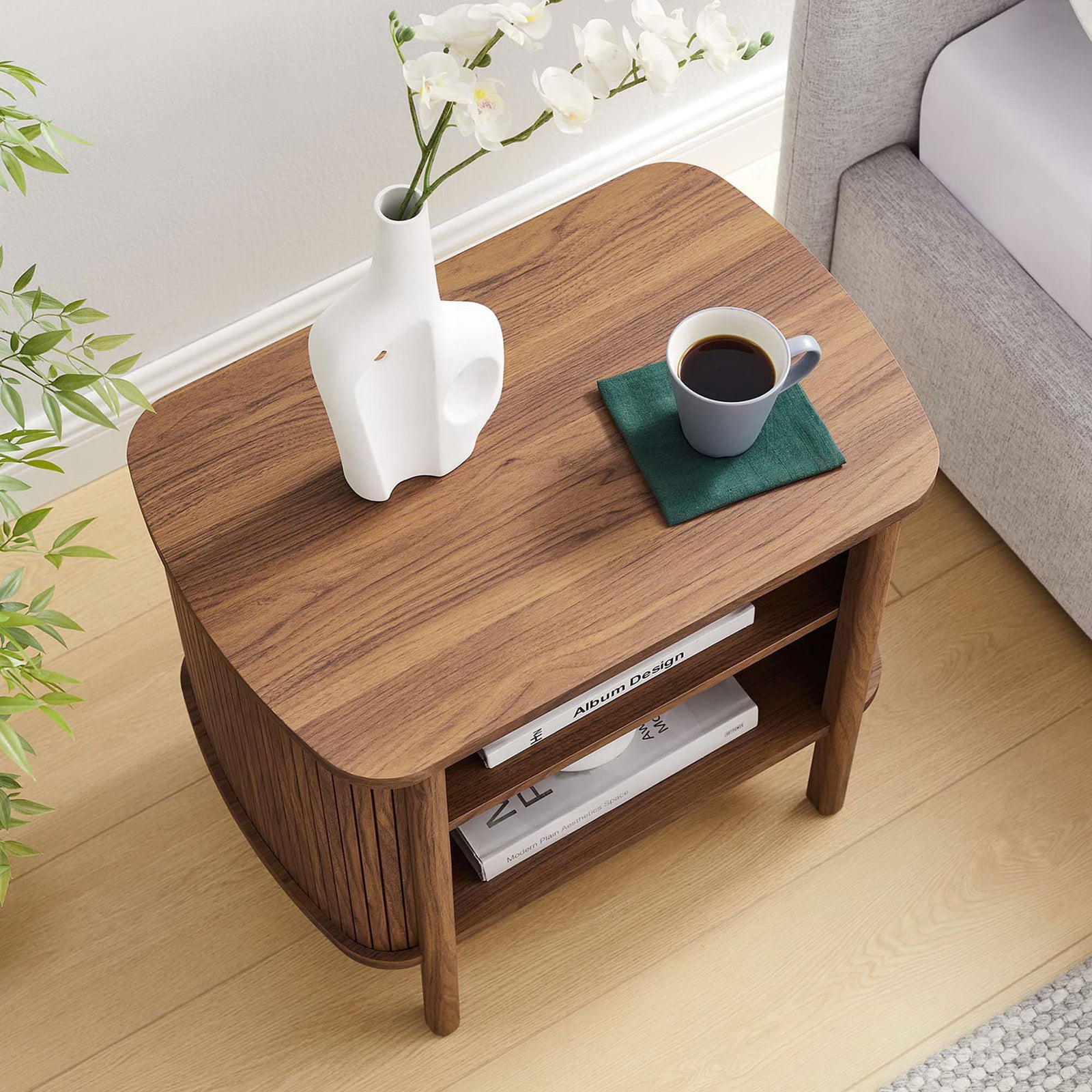 Nightstand styled bedside with books, vase, and coffee, highlighting its roomy shelves and warm walnut finish || MOD-7157-WAL || top_angle_room