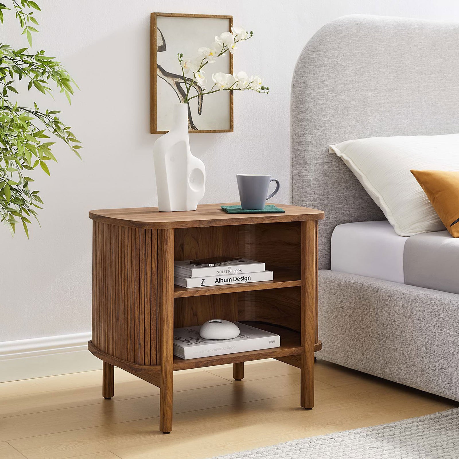 Cadence walnut nightstand next to a bed, styled with books and decor on open shelves || MOD-7157-WAL || front_angle_room