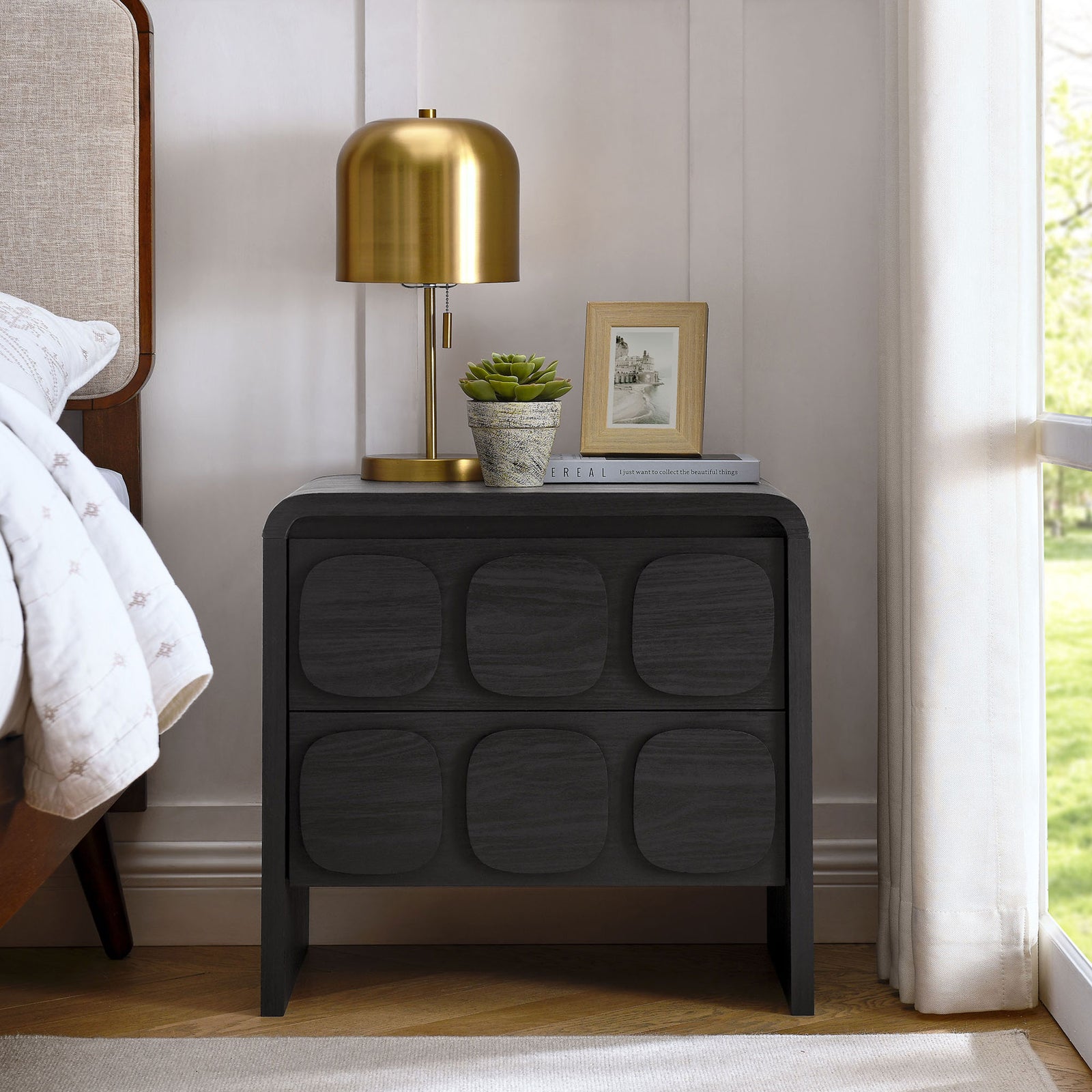 Black two-drawer nightstand beside a bed, highlighting sculpted circular drawer fronts and curved frame || MOD-7161-BLK || front_room