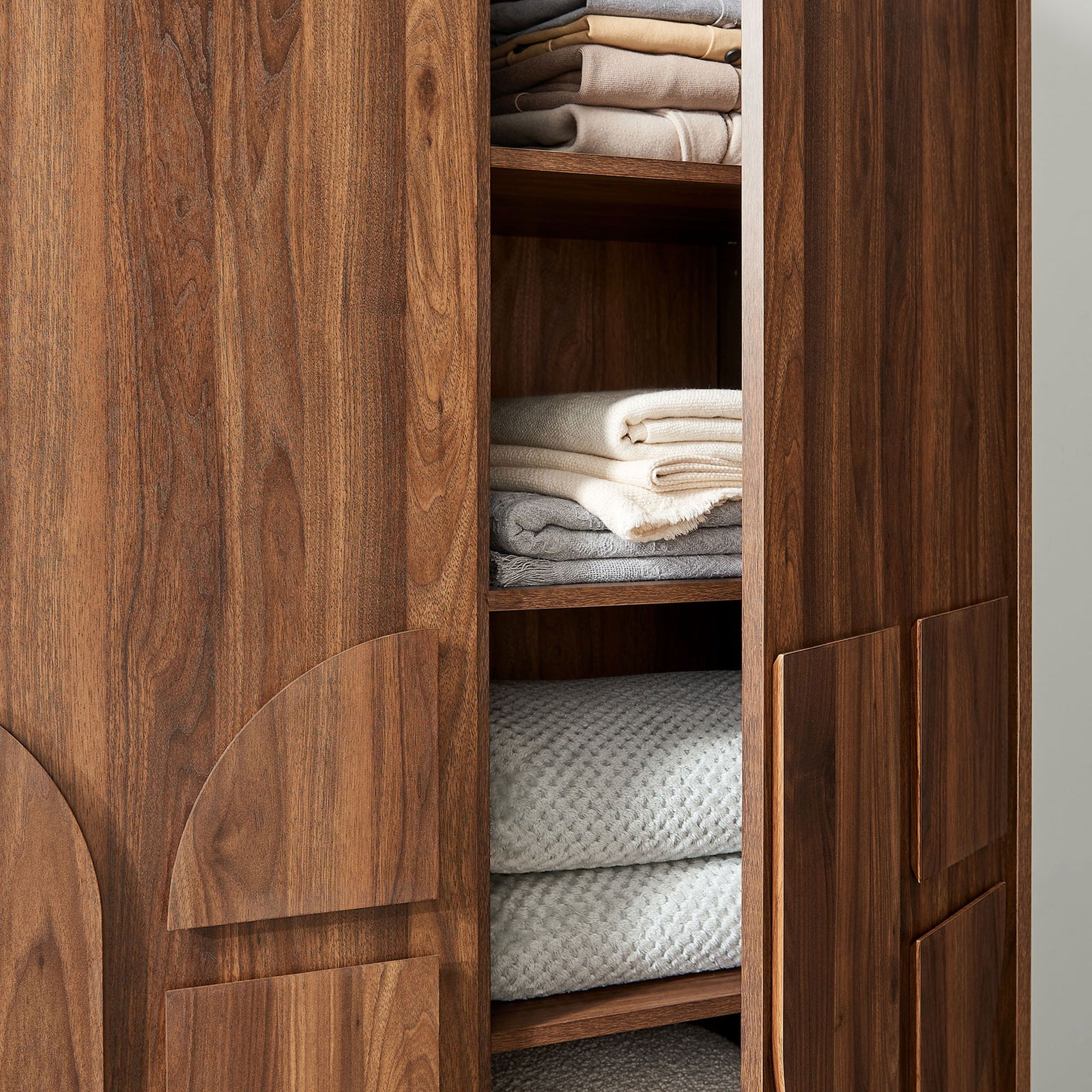 Wardrobe shelving neatly organized with folded towels and linens inside the walnut closet interior. || MOD-7164-WAL || storage_open_room