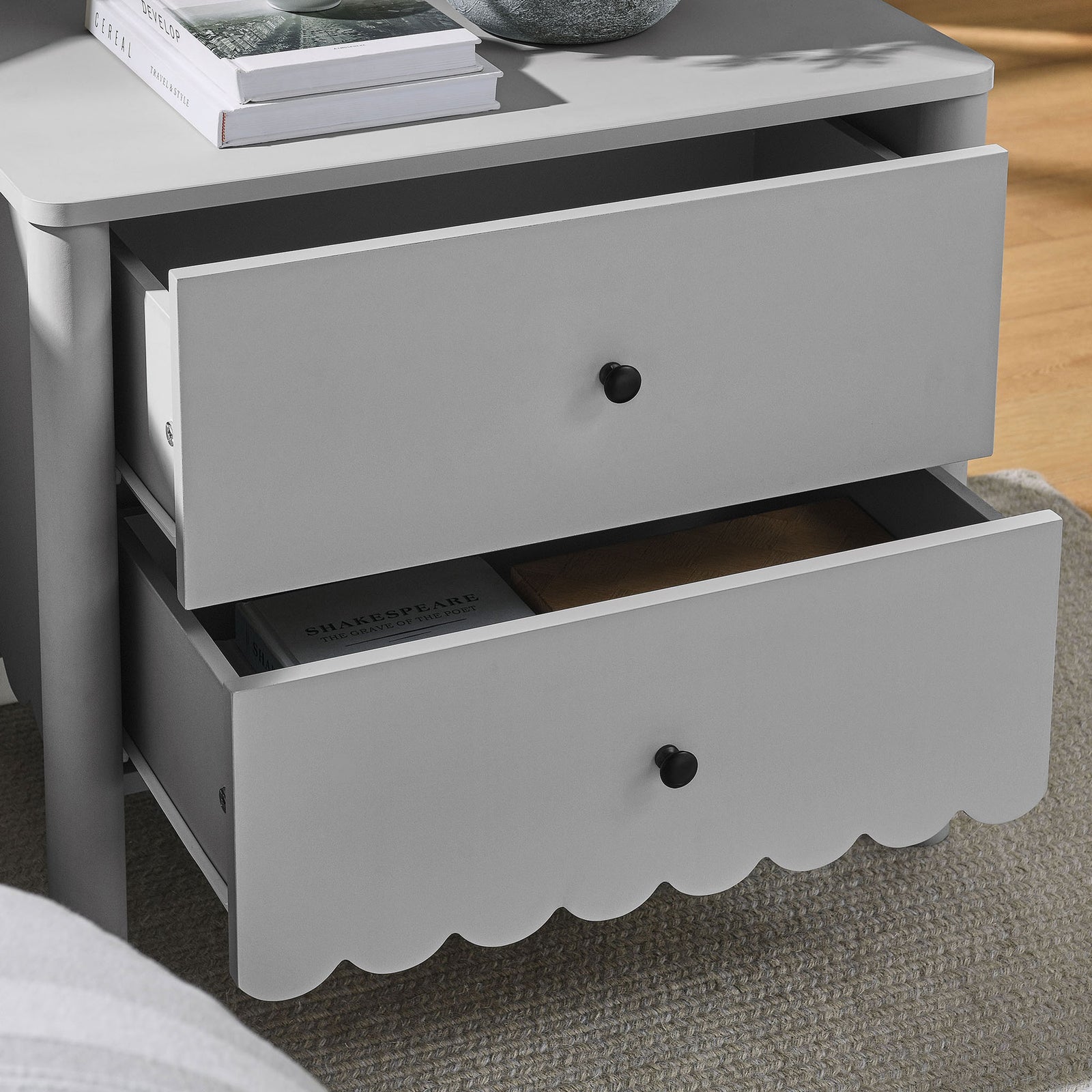 Nightstand beside bed with open drawers displaying books and decor in a cozy light gray finish || MOD-7206-LGR || storage_open_room