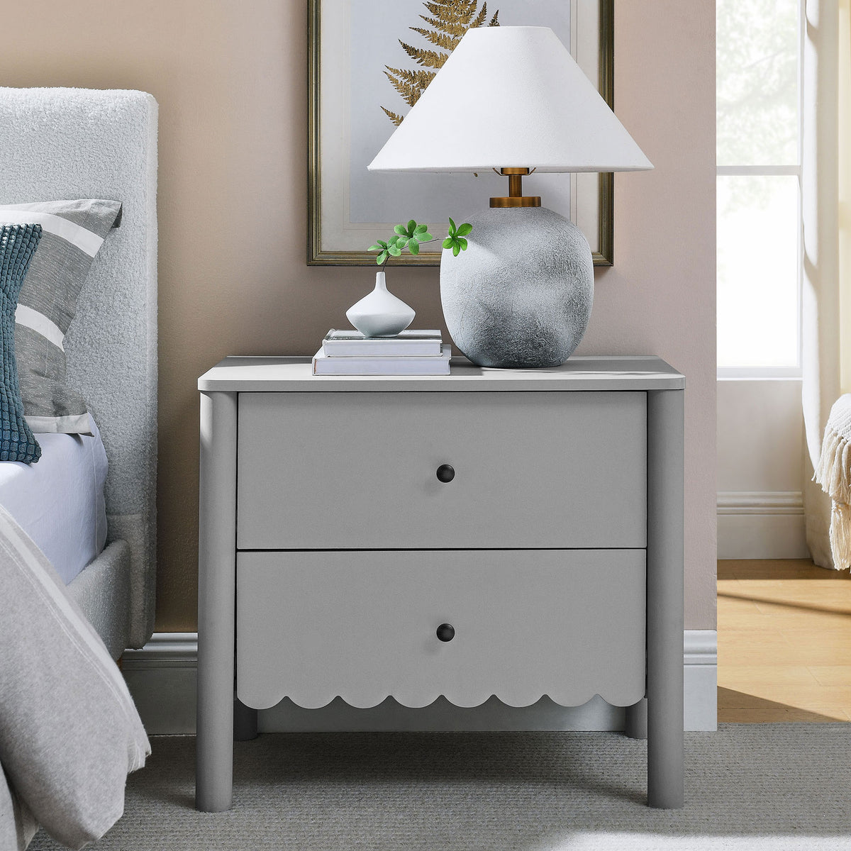 Light gray scalloped nightstand styled by the bed with lamp, vase, and books on the tabletop || MOD-7206-LGR || front_angle_room