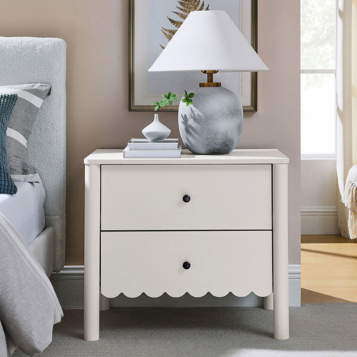 White scalloped nightstand styled with lamp, vase, and books beside a modern bed || MOD-7206-WHI || front_angle_room