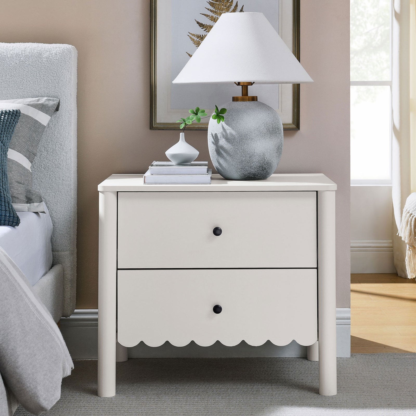 White scalloped nightstand styled with lamp, vase, and books beside a modern bed || MOD-7206-WHI || front_angle_room