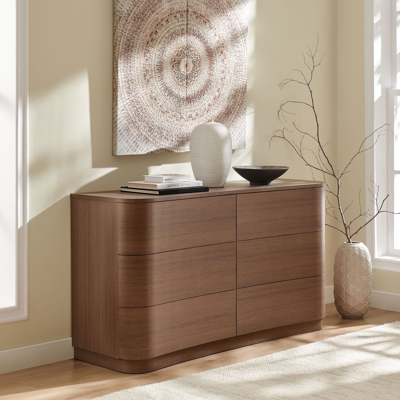 Mirae dresser styled in a bright bedroom, pairing curved lines with a warm brown oak finish and airy decor. || MOD-7229-BBO || front_angle_room