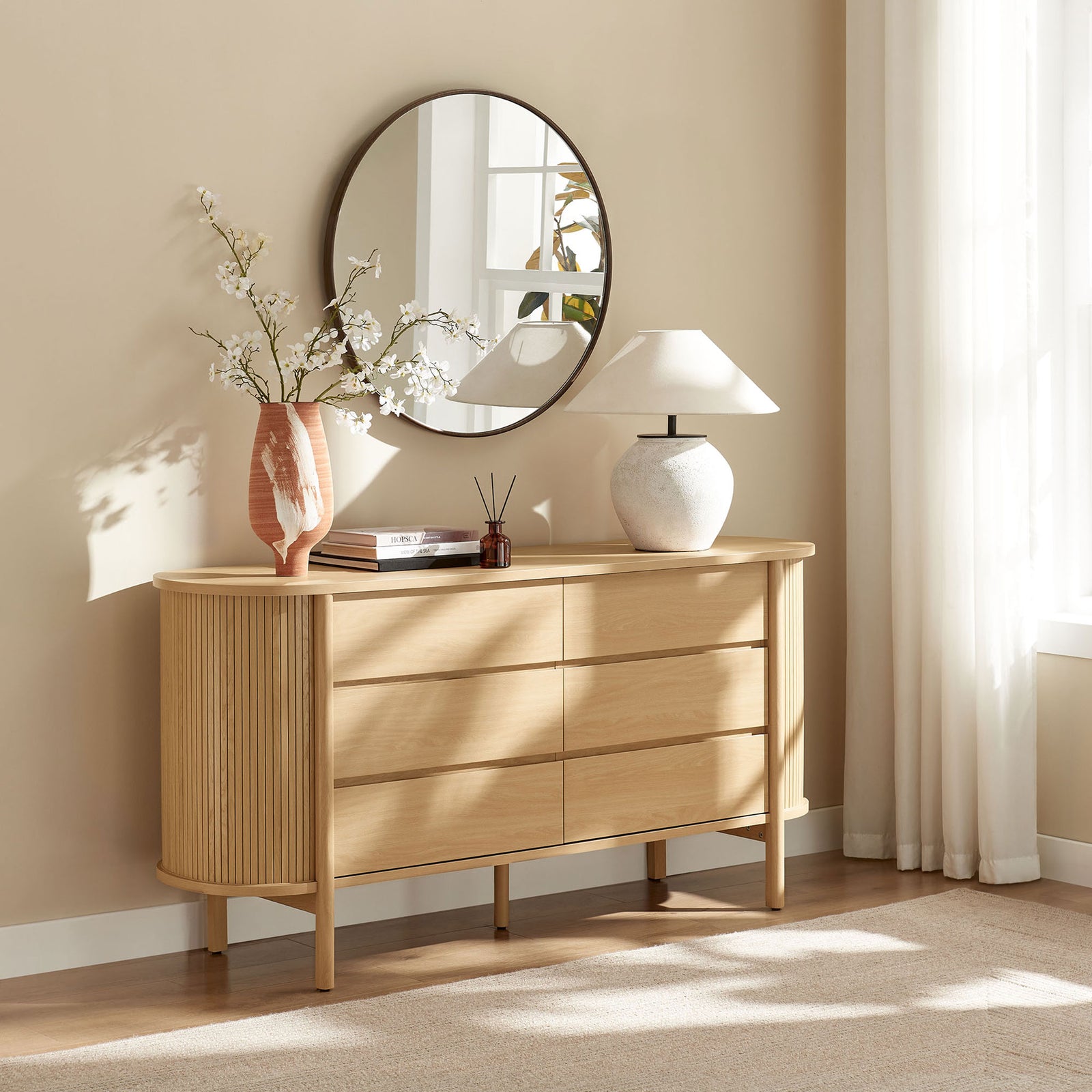 Oak six-drawer dresser styled in a bright bedroom with rounded silhouette and fluted side panels || MOD-7242-OAK || front_room