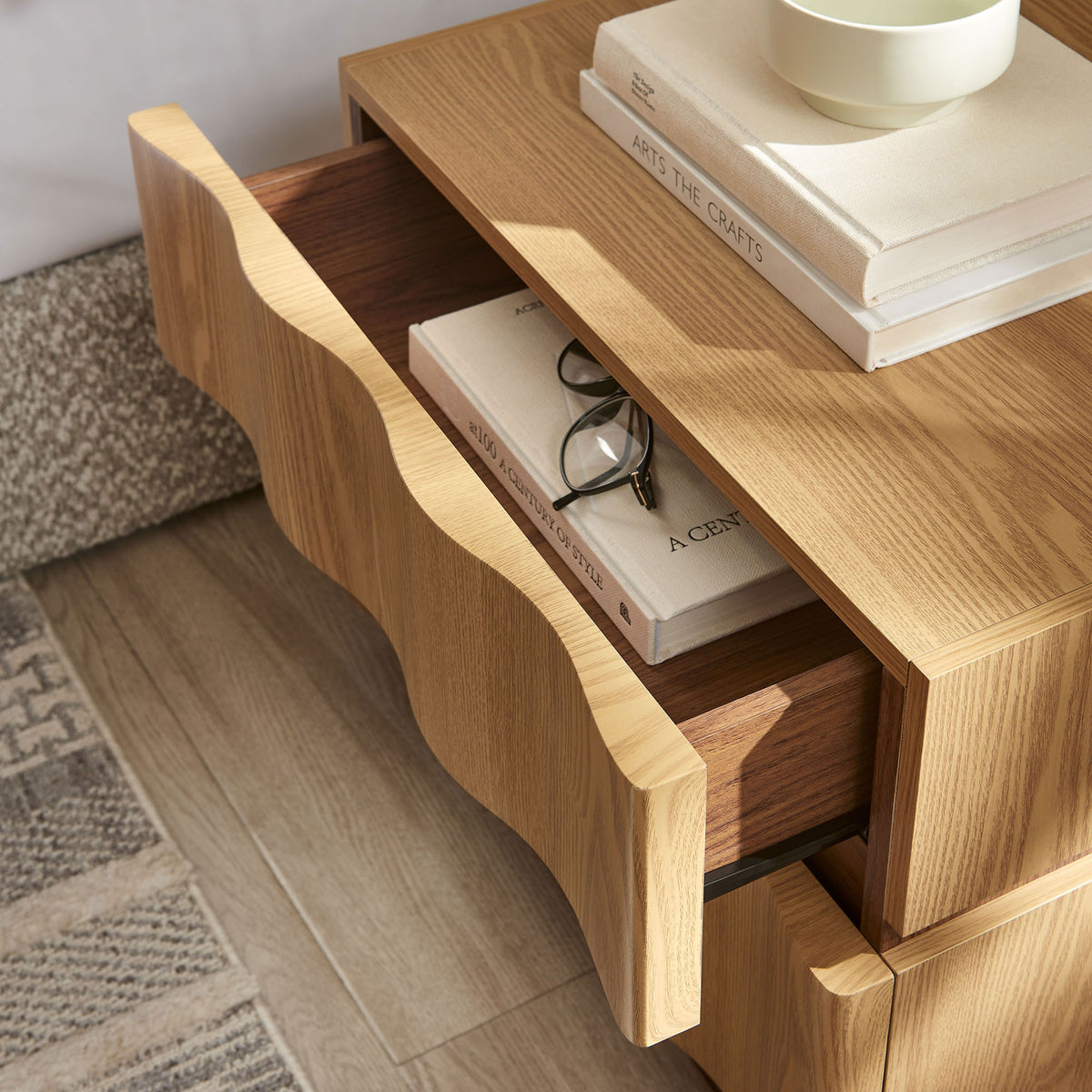 Isola nightstand beside the bed with the top drawer open and everyday essentials neatly arranged || MOD-7243-LOA-WAL || storage_open_room