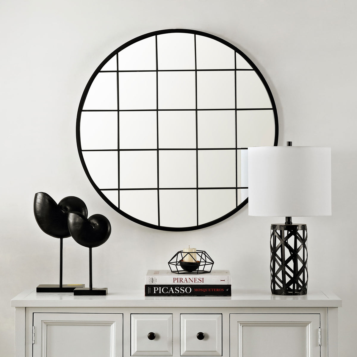 Round black grid mirror adds geometric interest above a white console