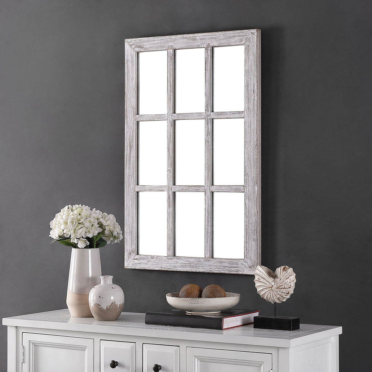 A weathered gray windowpane mirror adds rustic character above a white cabinet