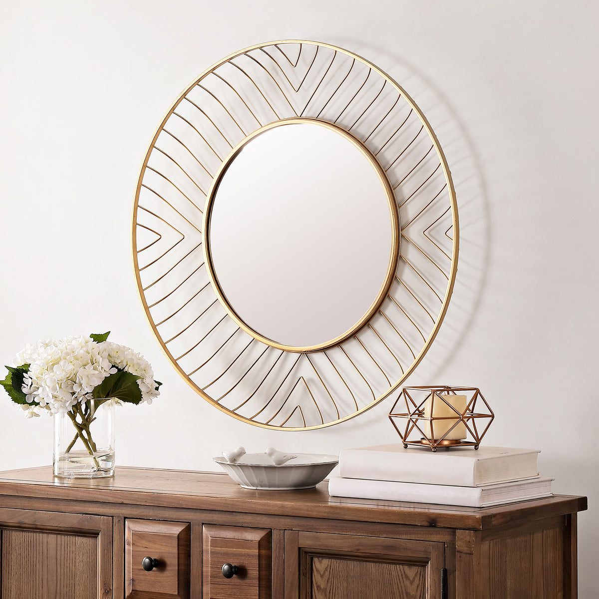 An airy gold geometric mirror adds a sculptural accent above a wood console || MRR1046A || front_room