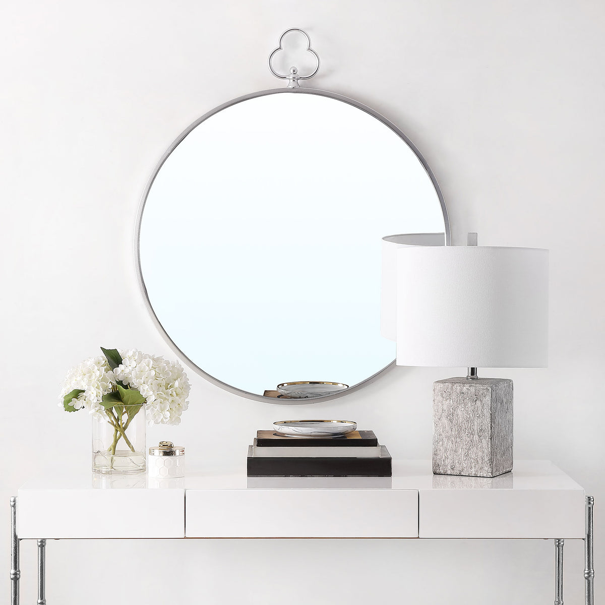 A silver-framed round mirror adds a graceful trefoil detail above a white console || MRR1050A || front_room