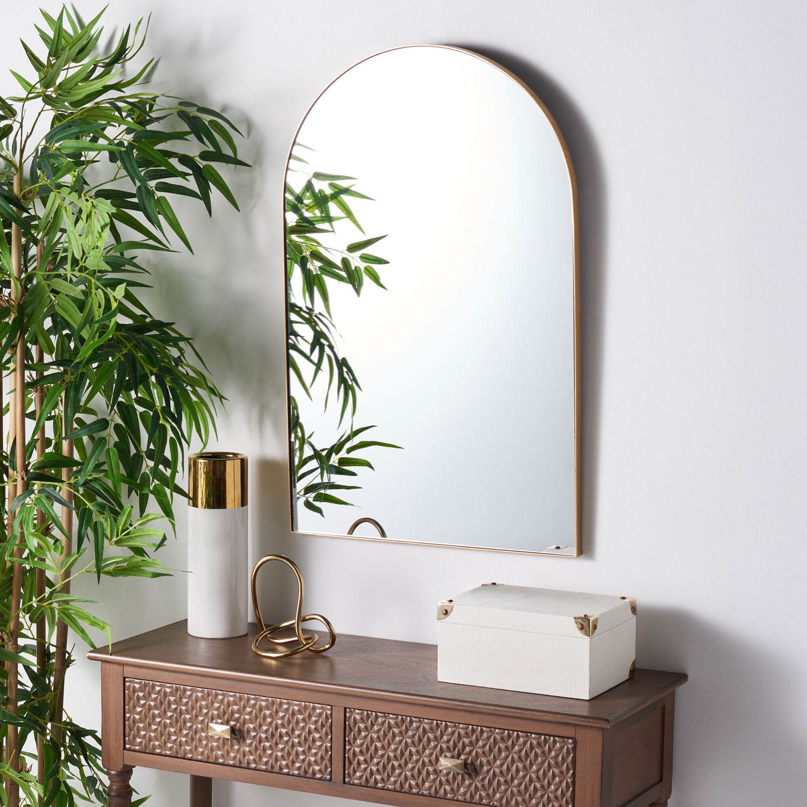 A gold-framed arched mirror lends warmth and openness to the wall above a console || MRR1055A || front_angle_room