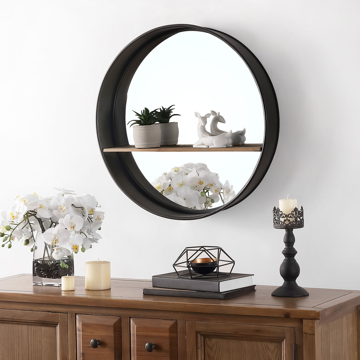 The wood shelf on this round black mirror displays greenery and sculptural accents || MRR1063A || front_room