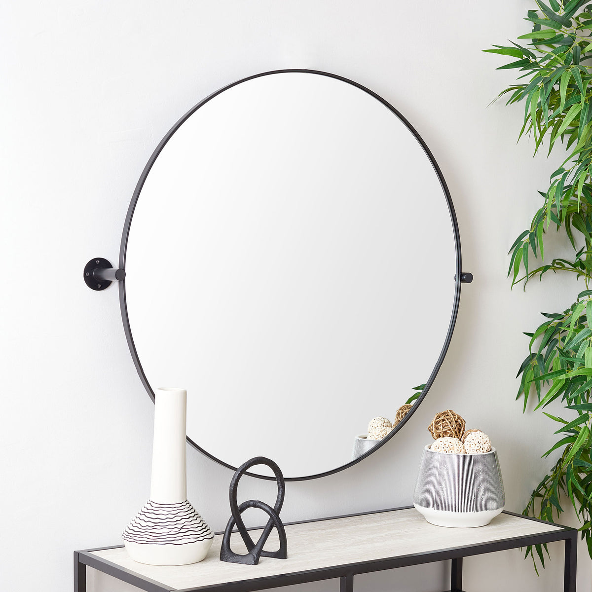 A round black-framed mirror with exposed side mounts anchors a bright, modern space || MRR2000B || front_room