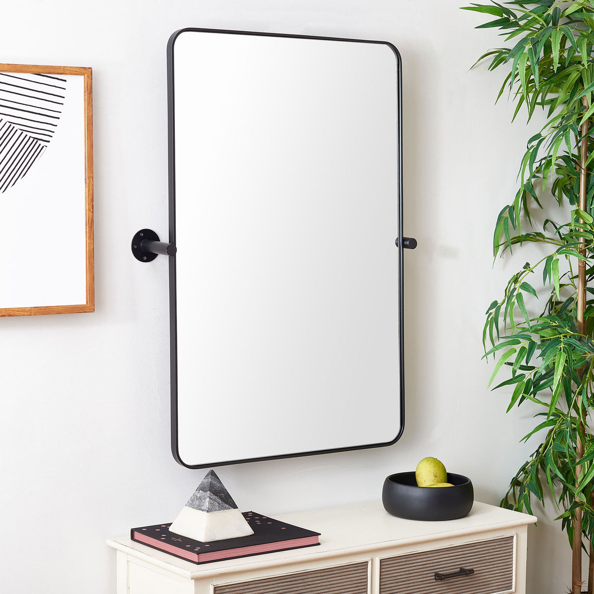 Black metal-framed wall mirror adds a clean accent above a light console and modern decor. || MRR2001A || front_angle_room