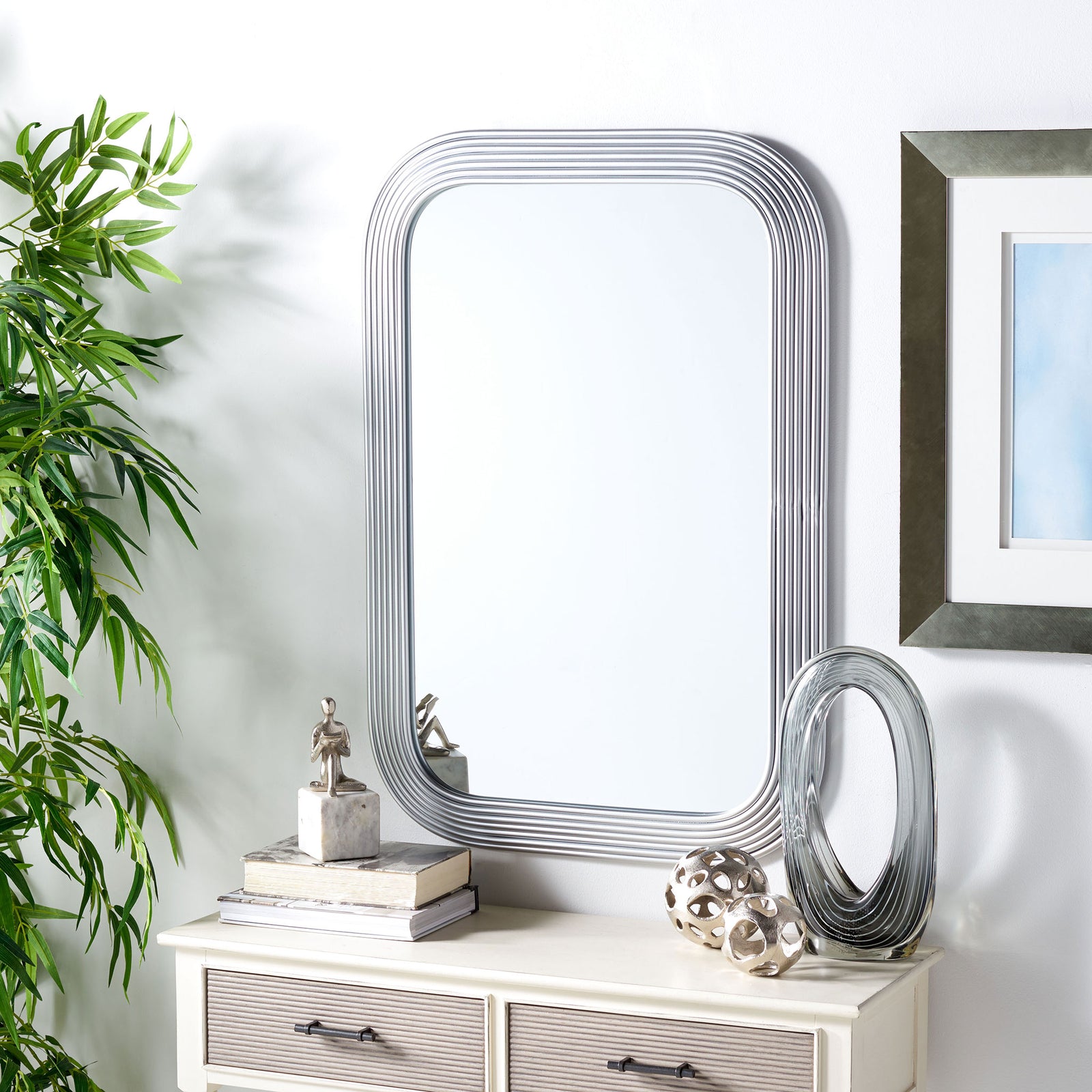 Silver ribbed mirror brightens the wall above a console with textured drawers || MRR2003B || front_room