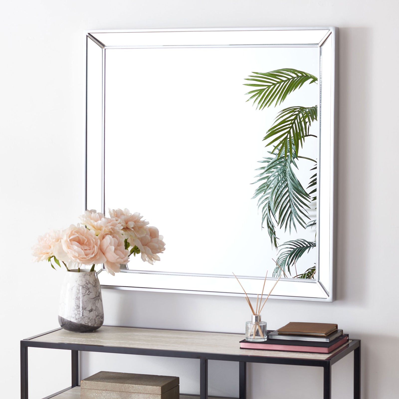 A square silver metal mirror brings a luminous accent and geometric lines to a console arrangement. || MRR2004C || front_room