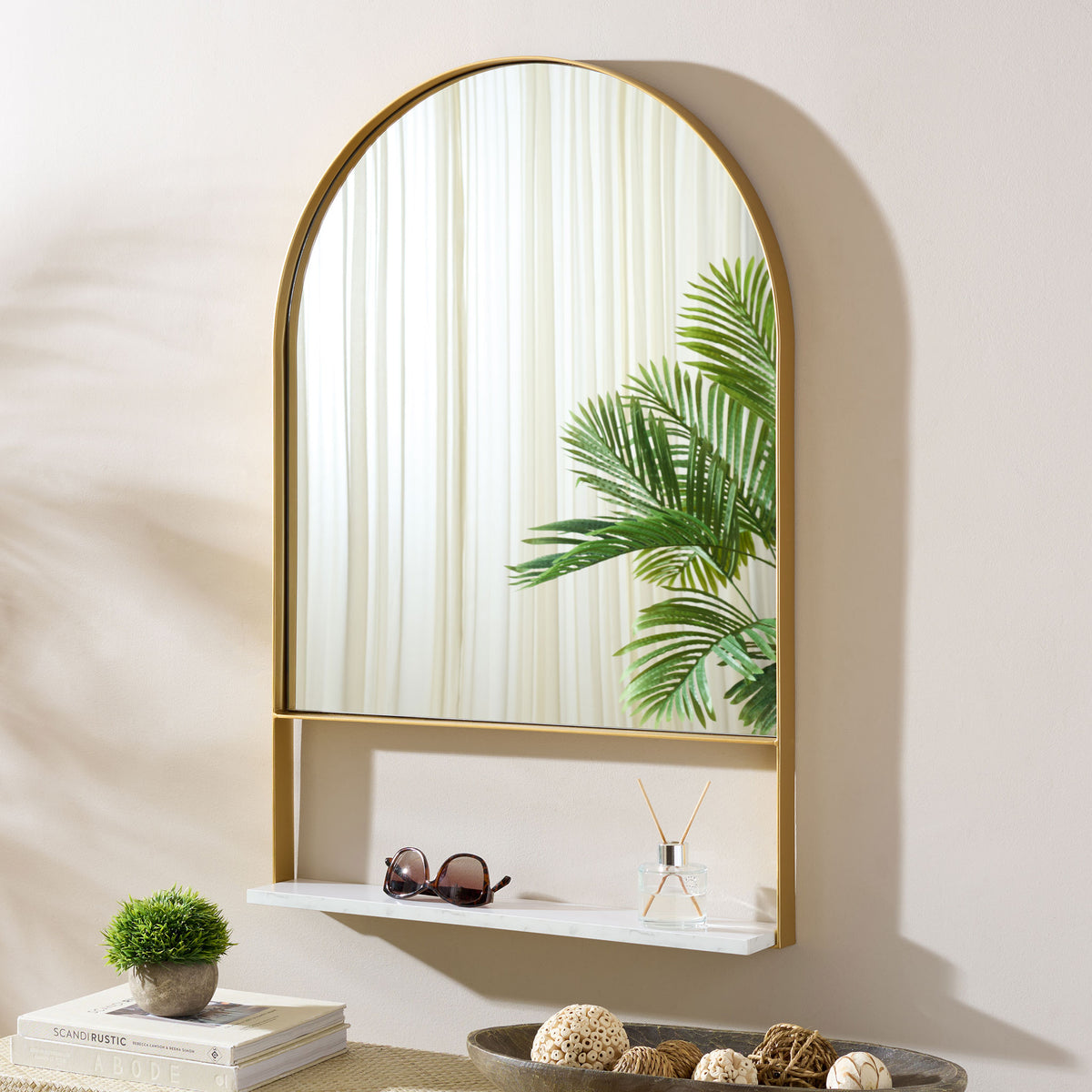 The brass-framed mirror brightens the wall, with a white shelf for glasses and a diffuser. || MRR2009A || front_room