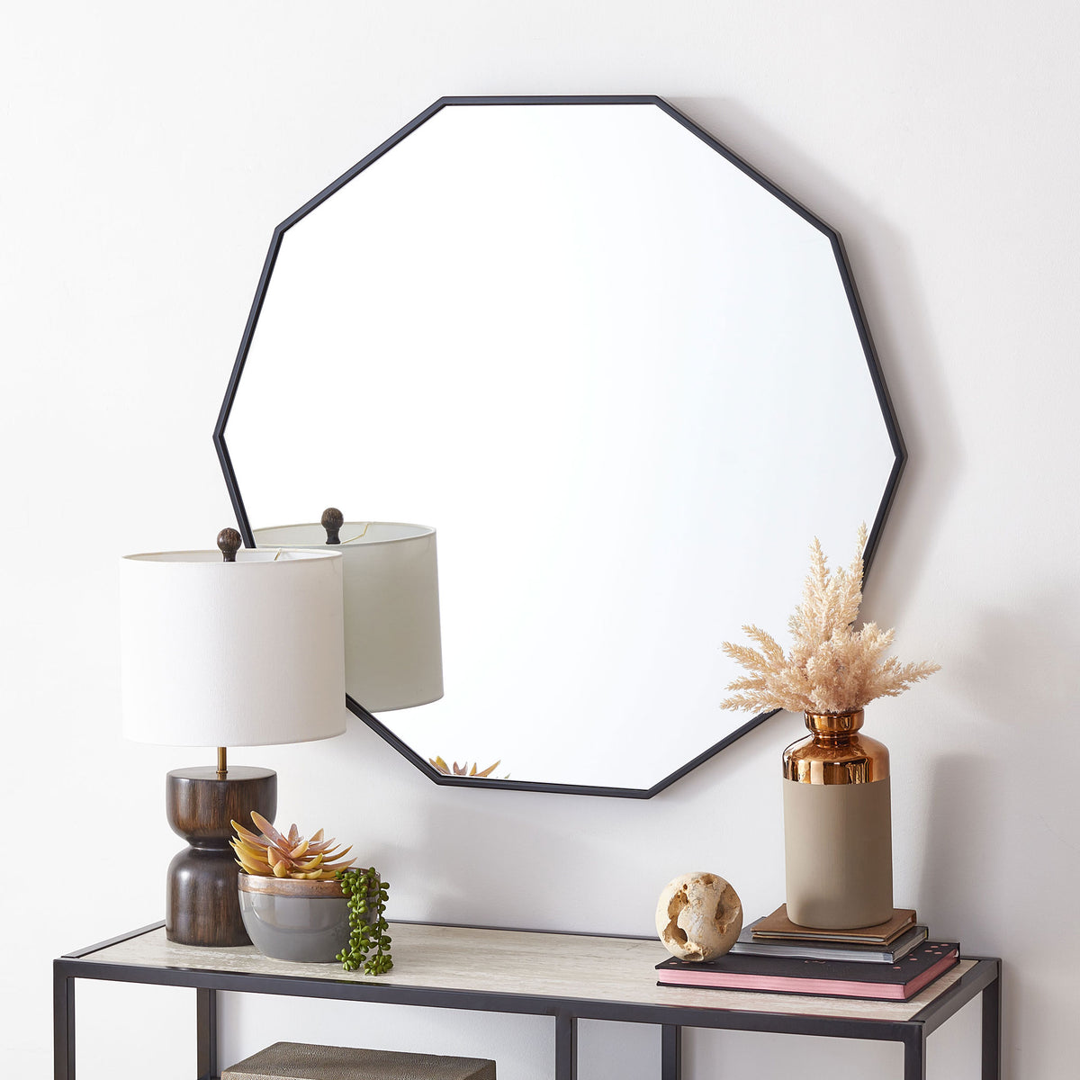 Black-framed geometric mirror adds a bold, clean-lined accent above a console table || MRR2010B || front_room