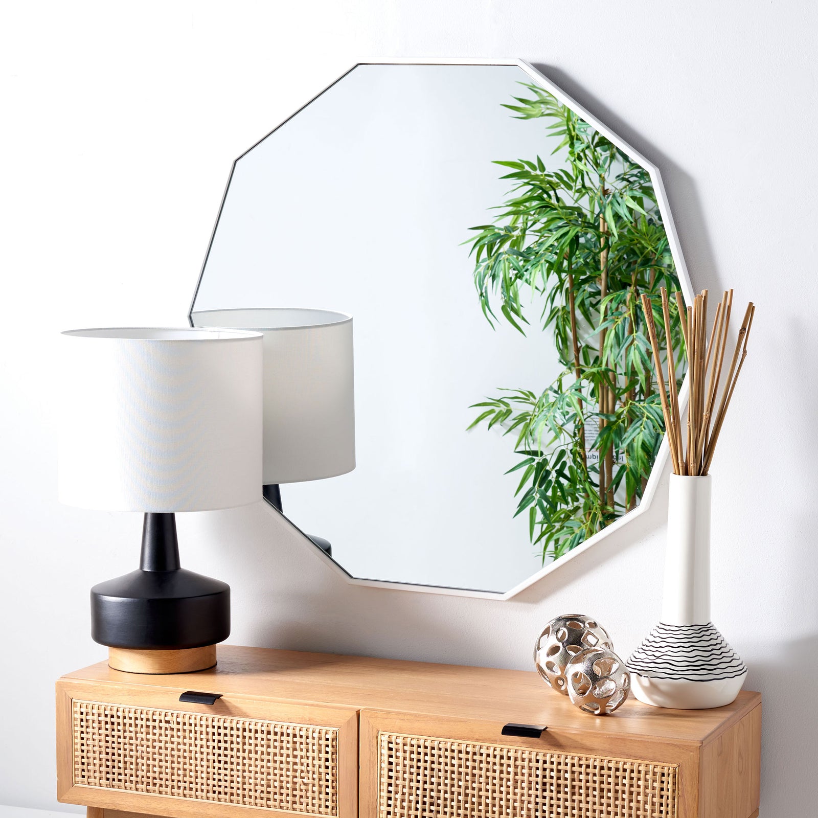 White-framed geometric mirror reflects greenery above a natural wood cabinet || MRR2010C || front_room