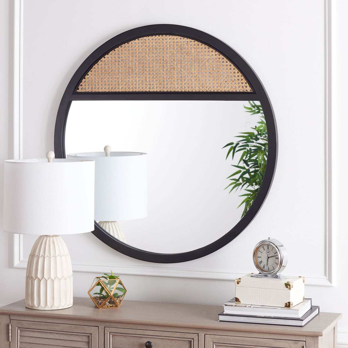 Black wood framing and an upper woven cane panel add contrast to a round mirror above a console || MRR2013A || front_room