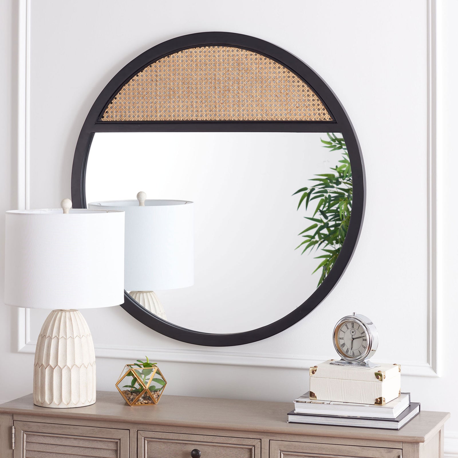 Black wood framing and an upper woven cane panel add contrast to a round mirror above a console || MRR2013A || front_room