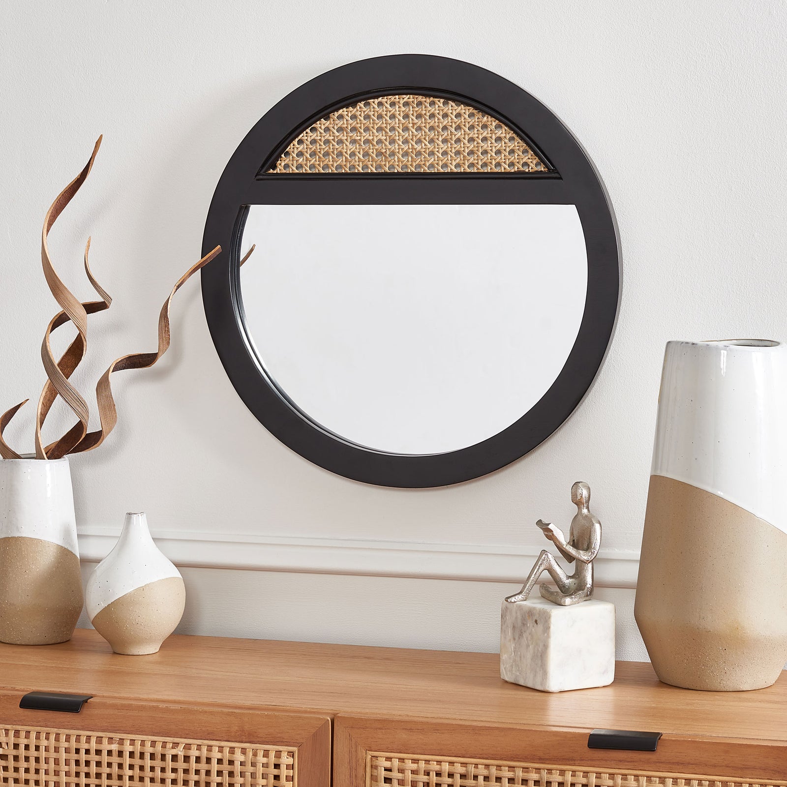 A black-framed mirror with a woven cane accent adds contrast above a wood console. || MRR2015A || front_room
