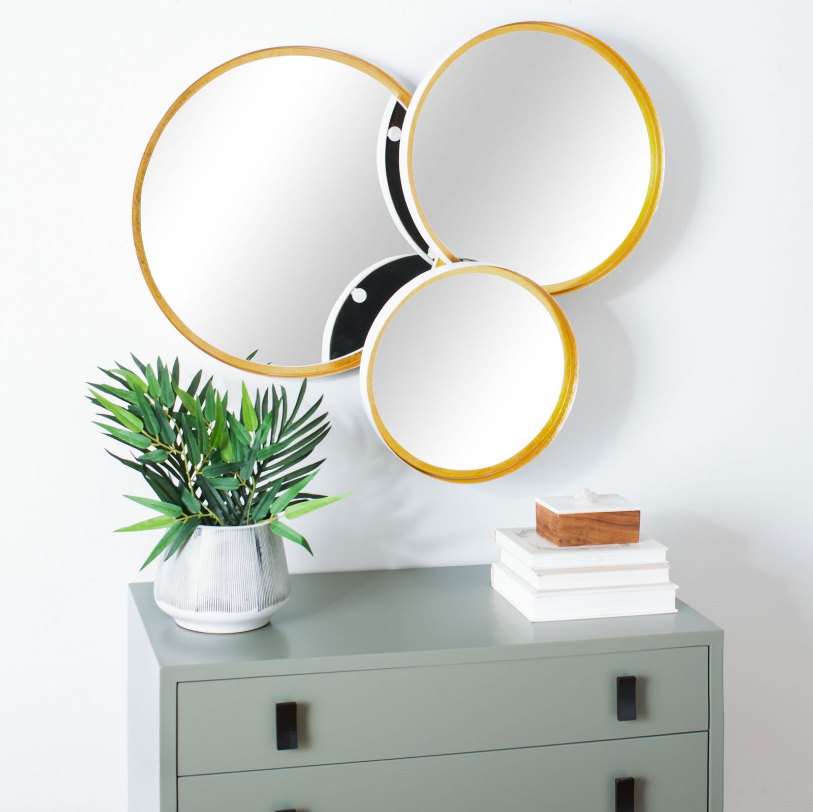 Three gold-trimmed round mirrors add sculptural shine above a cabinet, supported by dark metal. || MRR3002B || front_angle_room