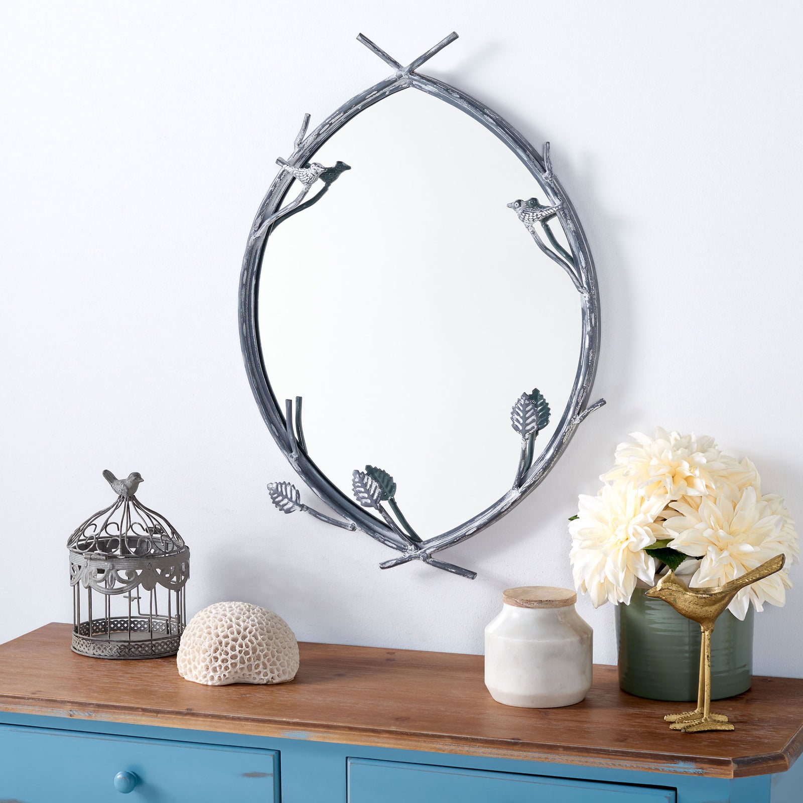 Silver twig accents lend this mirror a natural touch above a blue console. || MRR3043A || front_room