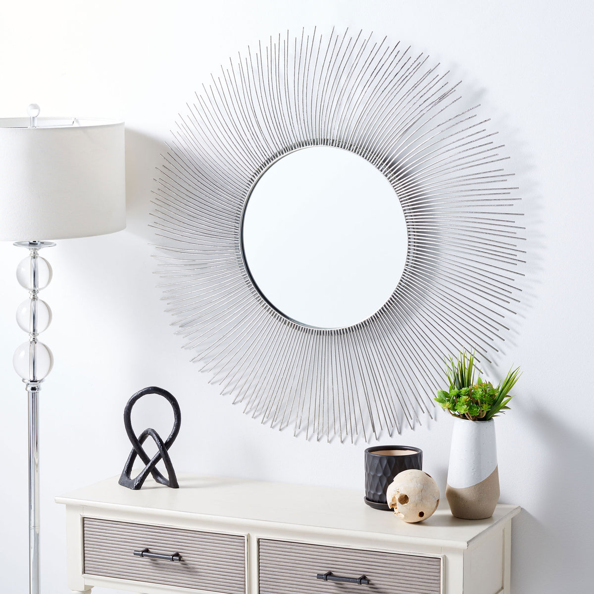 Silver sunburst mirror brings a bright focal point above a console table