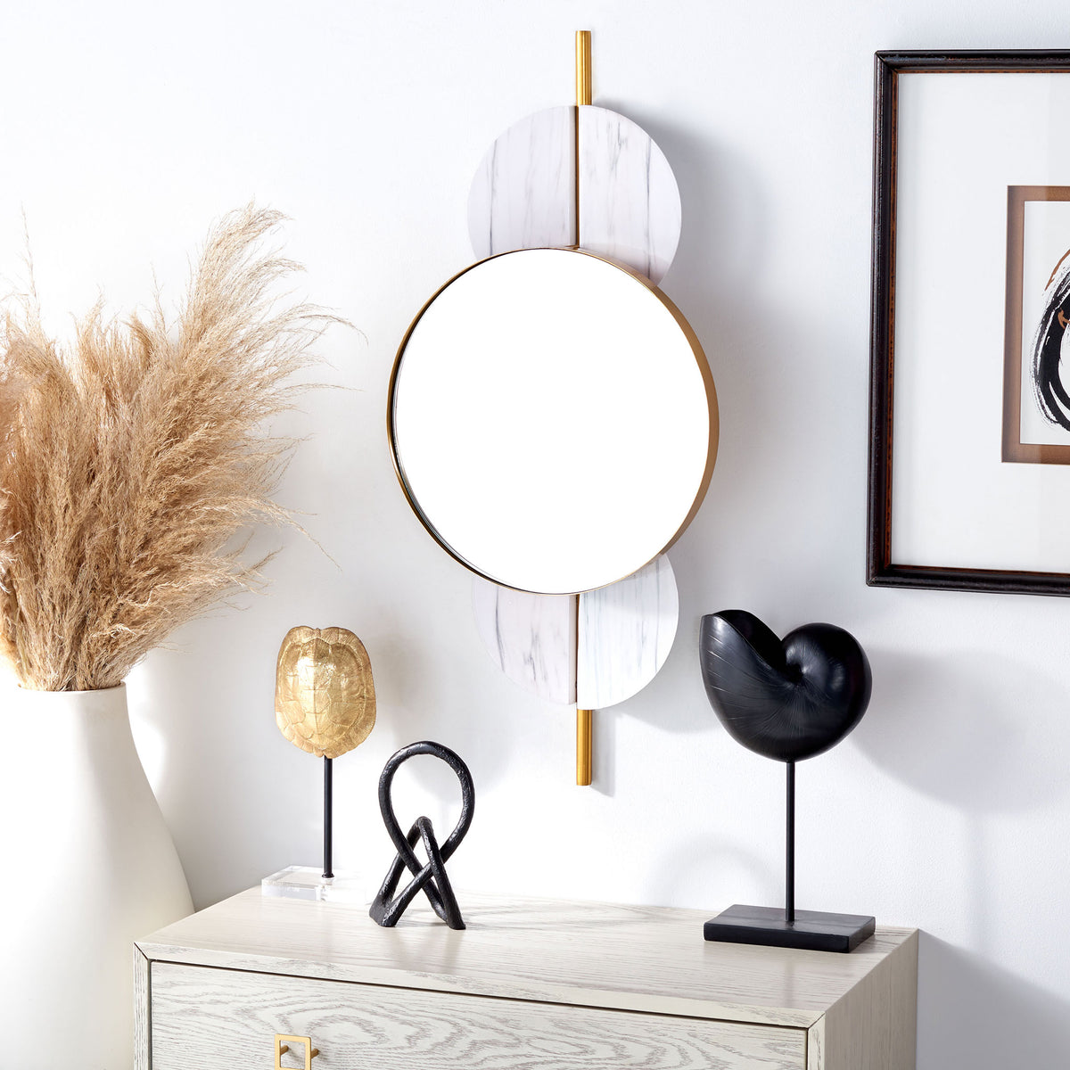White marble-look accents and gold trim lend a light, refined look to this round wall mirror