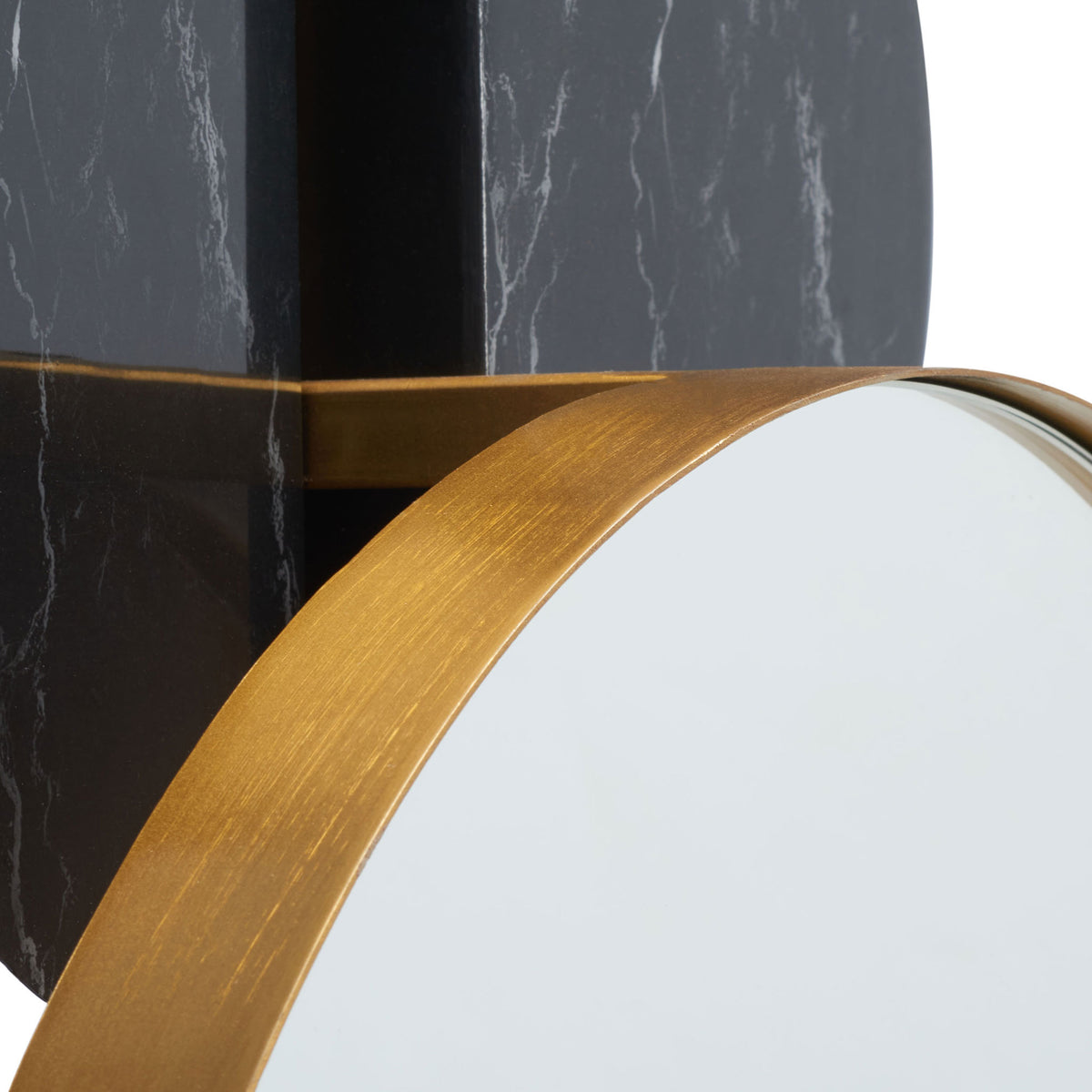 Brushed gold edging frames the round mirror against a black marble-look backing