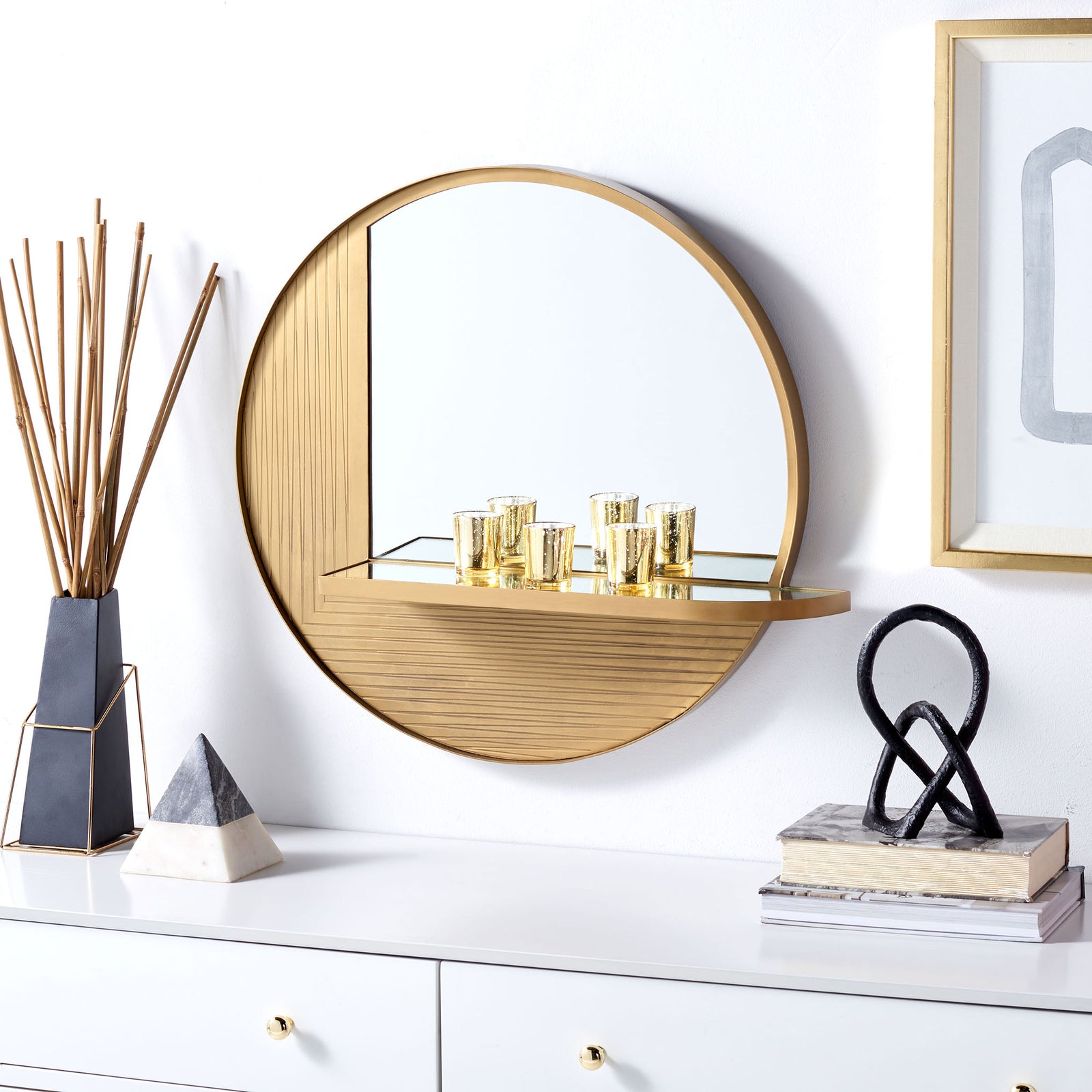 A slim shelf holds small accents on this round brass-finish mirror, while grooved detailing adds warmth. || MRR3050A || front_room