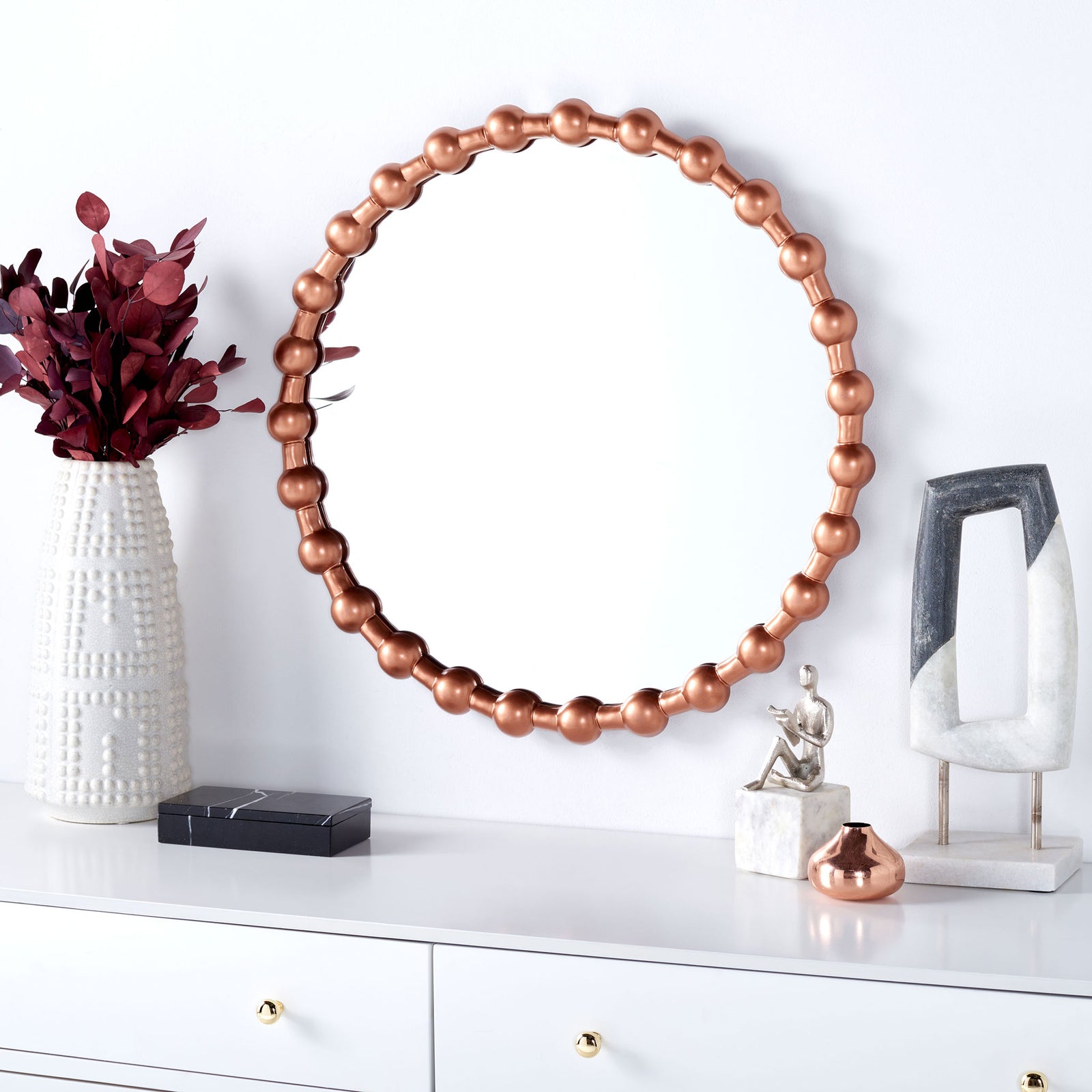 Copper-finished beaded mirror brings warmth to a bright room above a white dresser || MRR3053A || front_room