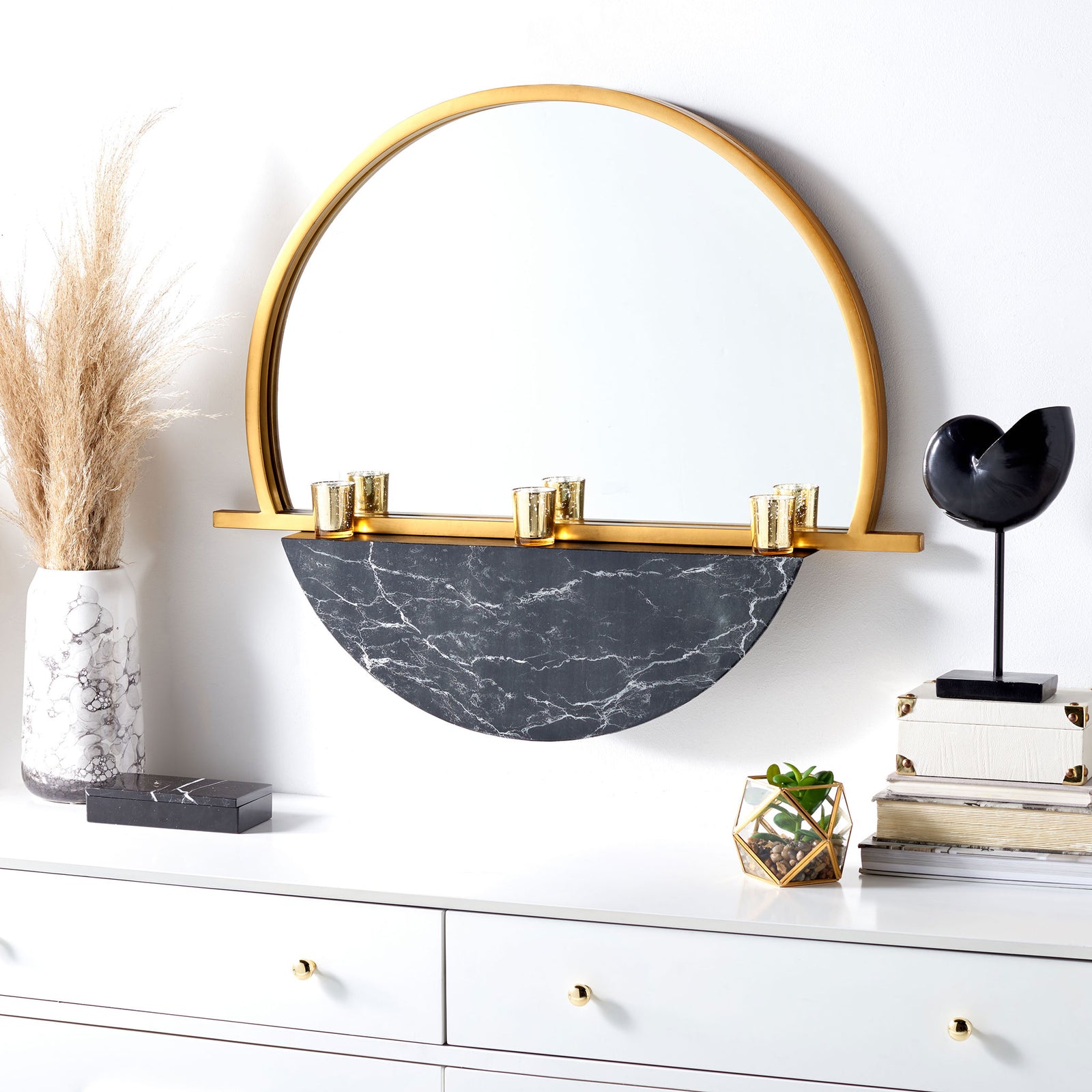 A gold arched mirror with a black marble-look lower panel creates a sculptural focal point above a white dresser || MRR3058A || front_room