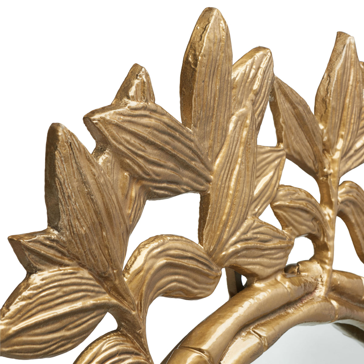 Raised leaf veins and branching stems add texture to the mirror's warm metallic frame