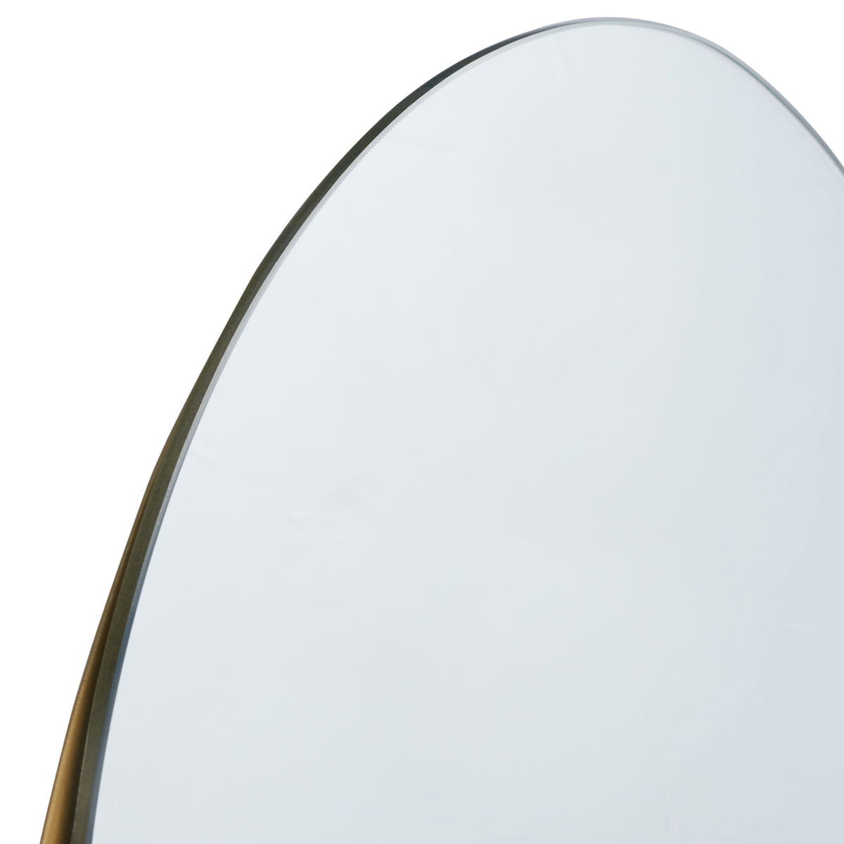 A slender brass frame traces the mirror's softly curved upper edge || MRR3063A || detail_studio