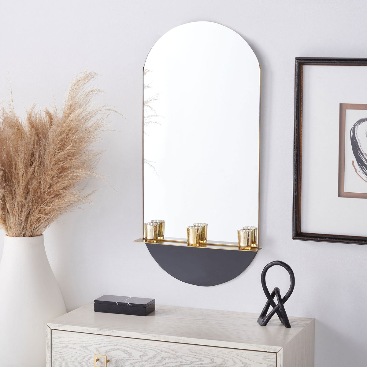 A wall-mounted arched mirror offers a brass display ledge and a contrasting black base || MRR3063A || front_room