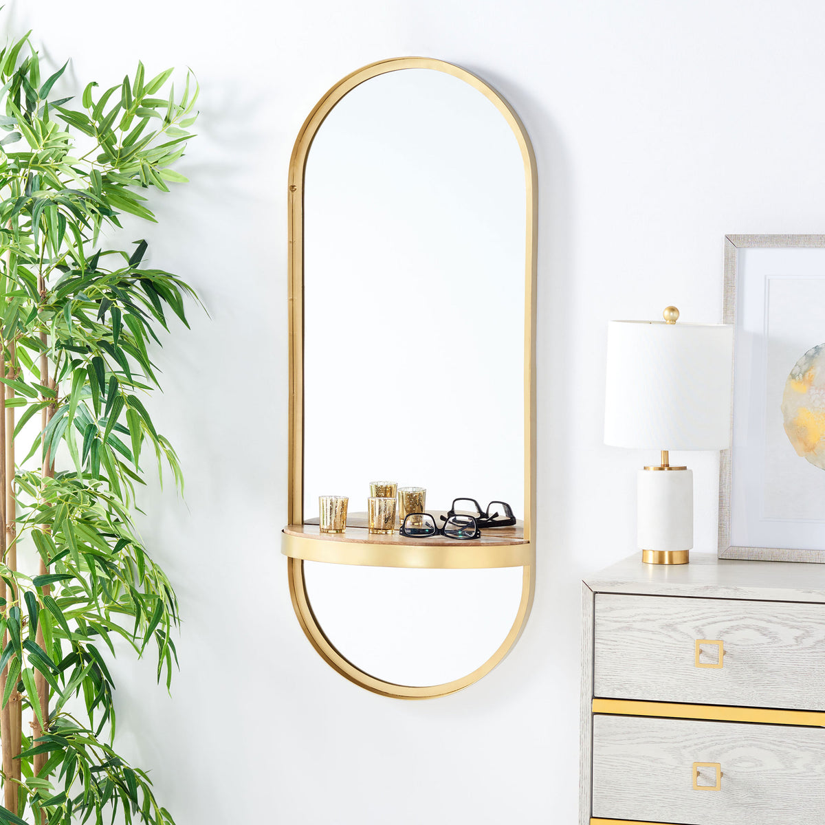 A rounded wall mirror brings a warm brass accent and a shelf for eyewear and small accessories.
