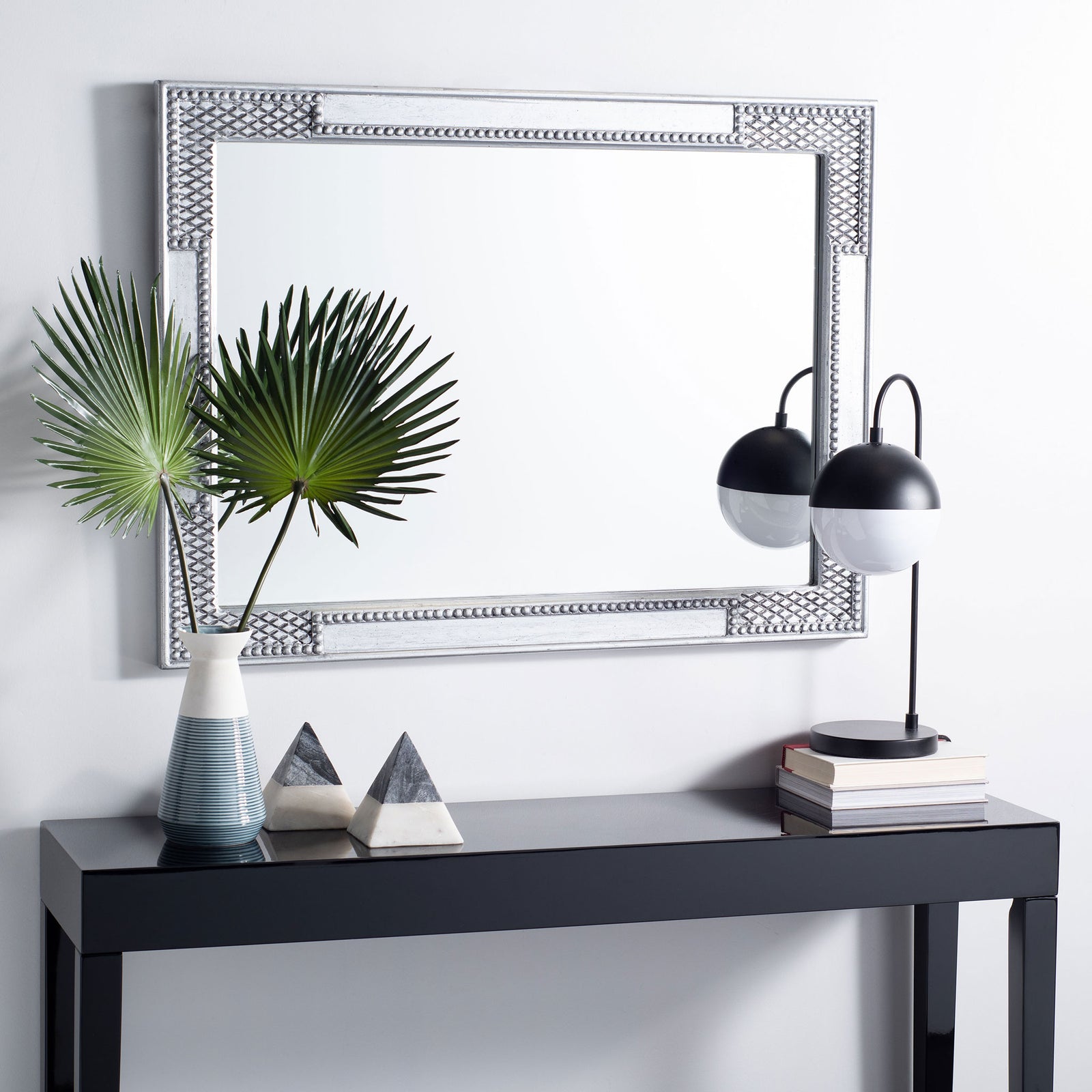 Antique silver mirror hangs horizontally above a console, adding ornate texture to the room || MRR5003B || front_room