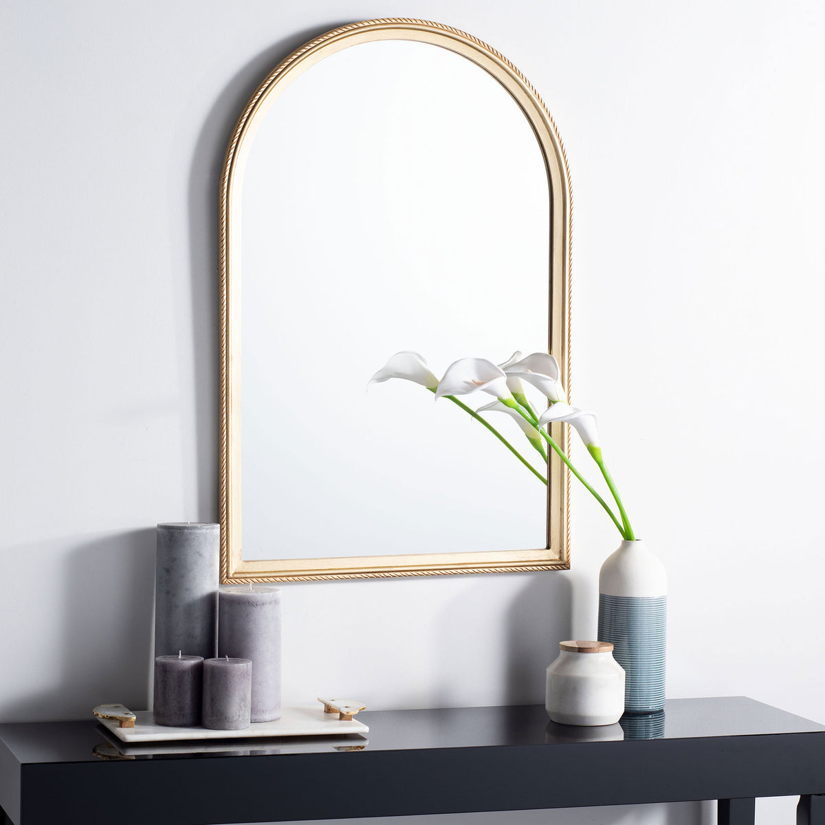 An arched gold mirror lends airy elegance above a modern console || MRR5004A || front_room