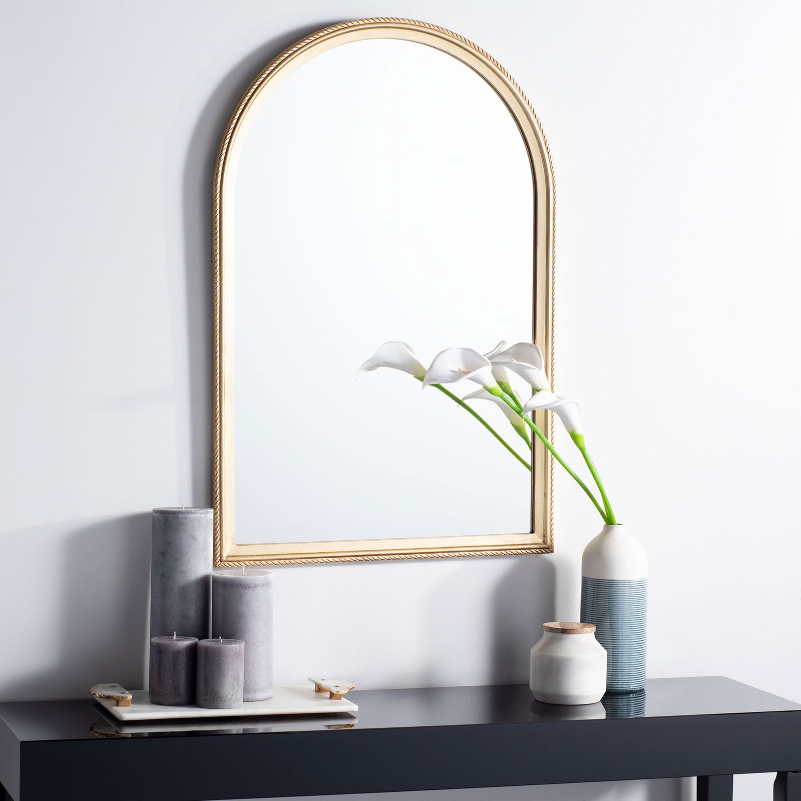 An arched gold mirror lends airy elegance above a modern console || MRR5004A || front_room