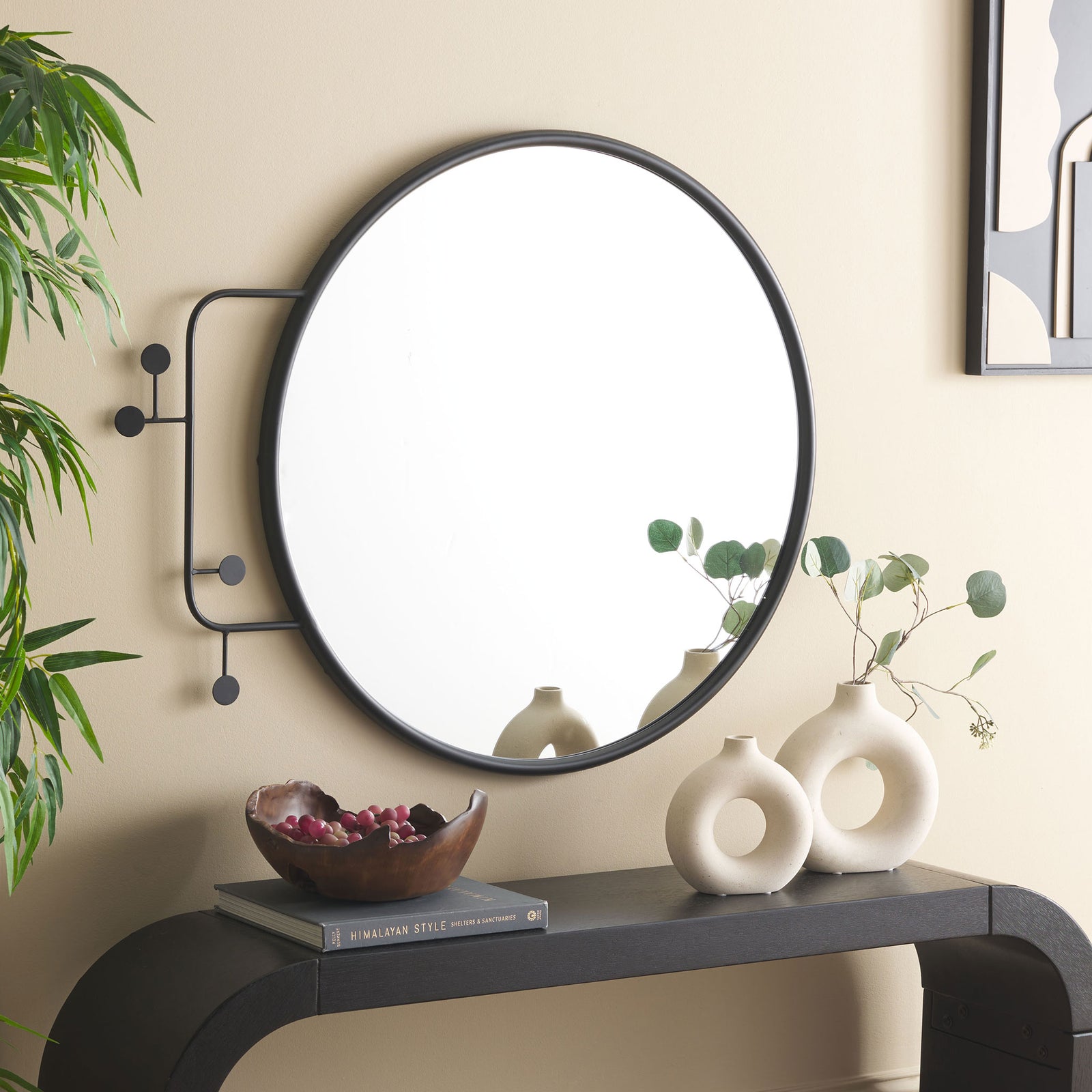A circular black mirror with asymmetrical, disc-tipped iron accents brings graphic style to the wall. || MRR8009A || front_room