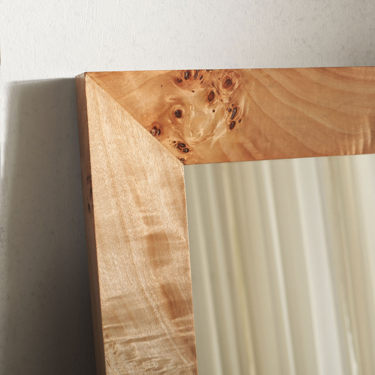 Warm burl grain and a mitered corner lend natural character to the mirror frame.