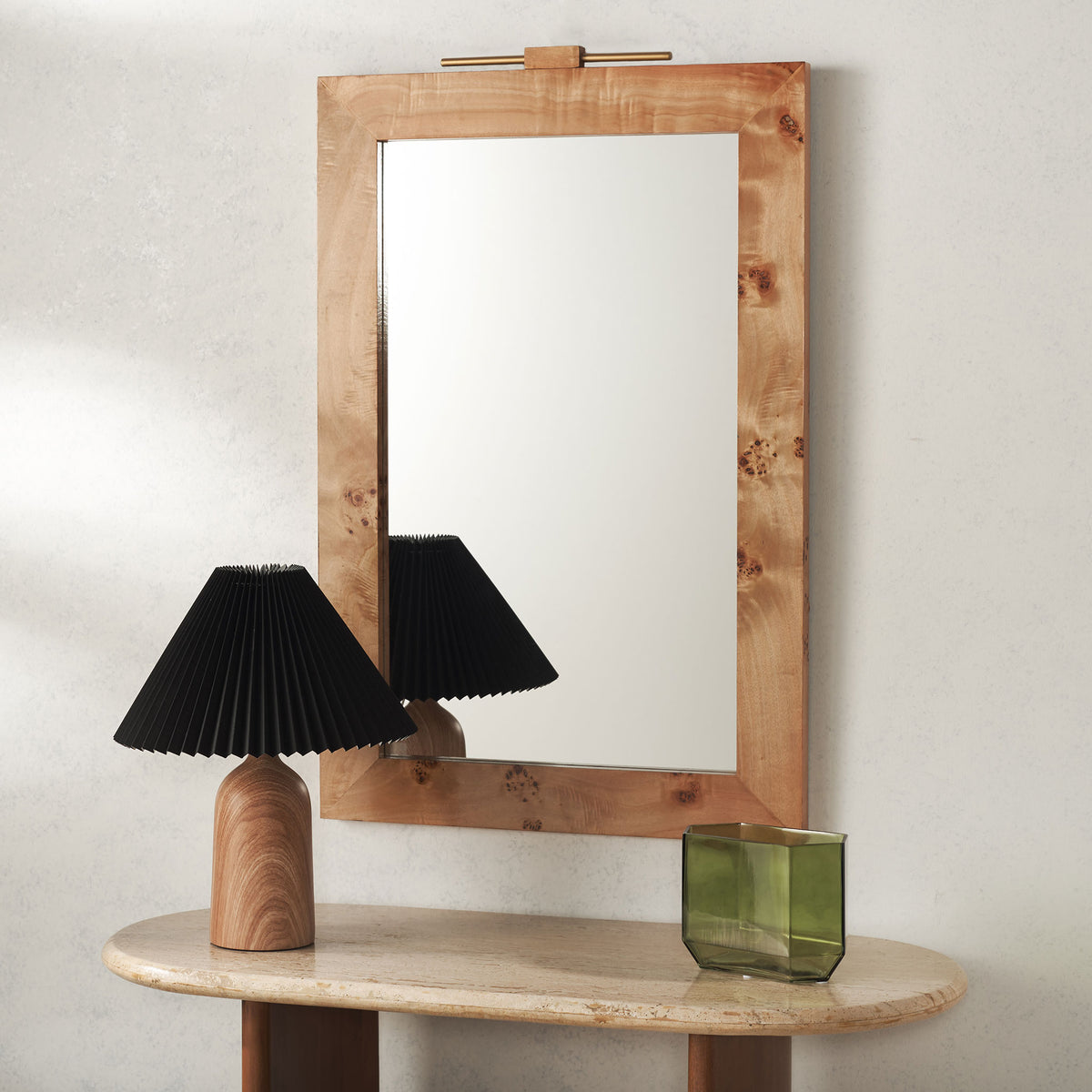 A light wood wall mirror with organic knots and a slim gold-tone accent adds warmth above a console. || MRR9015A || front_room