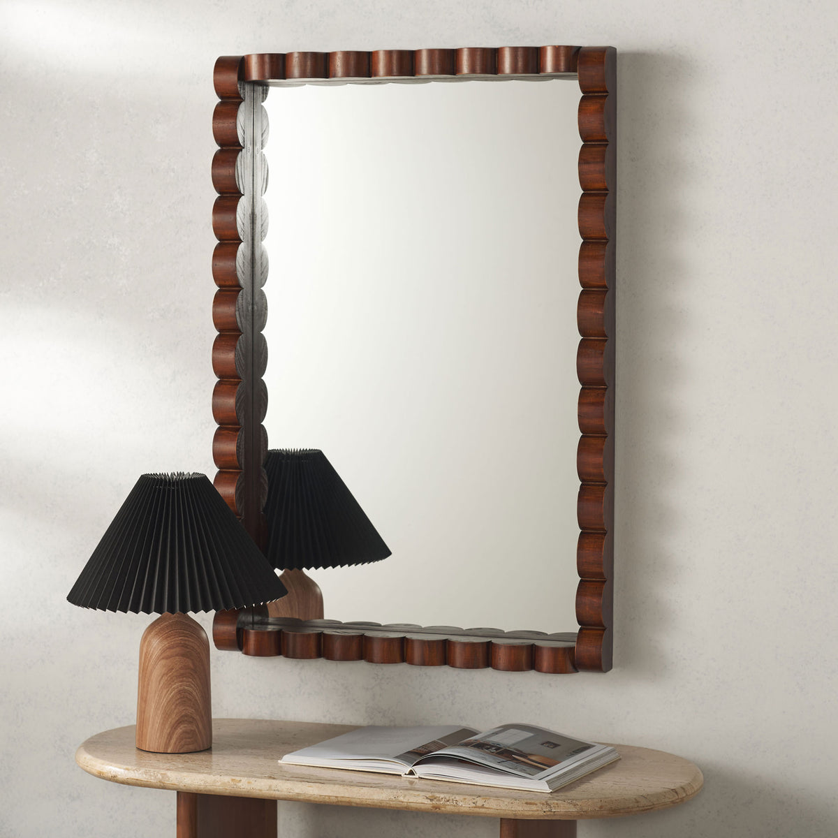 Walnut-toned sculpted wood adds warmth to a rectangular mirror above a stone console || MRR9023A || front_room