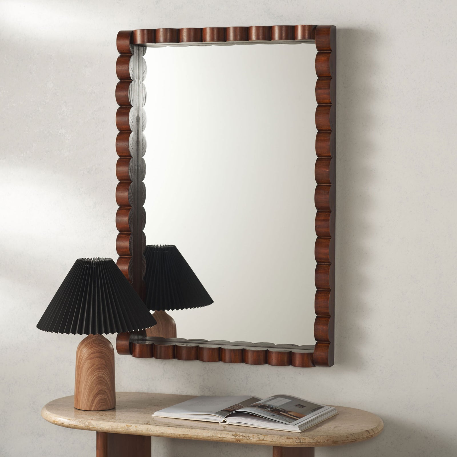 Walnut-toned sculpted wood adds warmth to a rectangular mirror above a stone console || MRR9023A || front_room